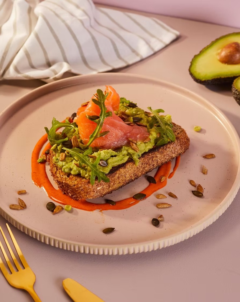 Smoked salmon and avocado toast on a pink plate