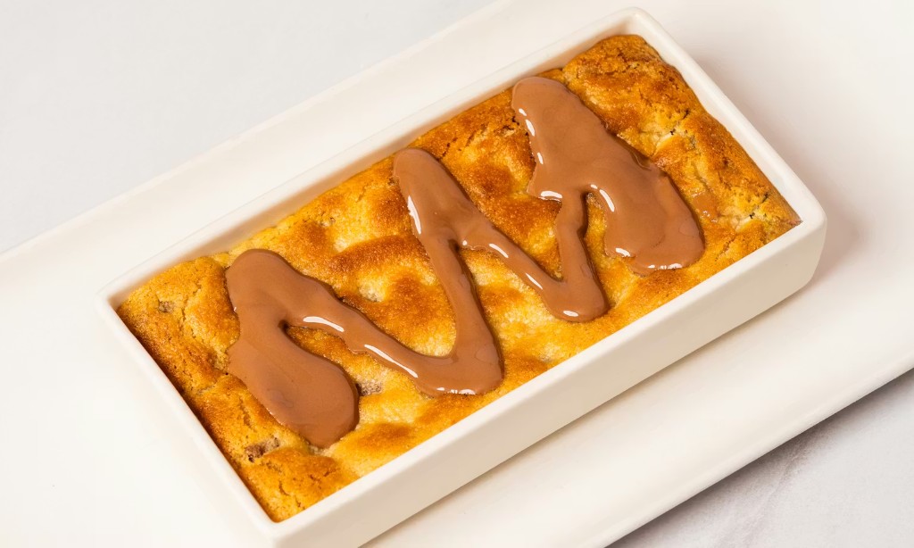 Blondie bar with zigzag chocolate drizzle in a white dish